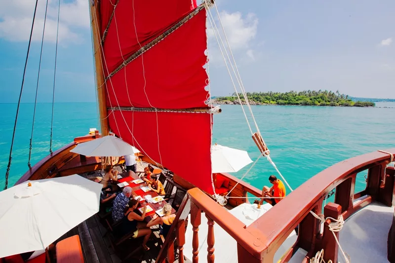 view of guests enjoying buffet lunch on the red sailed sailing junk the red baron near koh samui