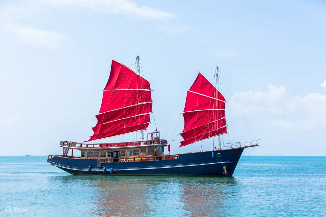 perfect shot of the blue hulled, red sailed, traditional sailing junk, the red baron, koh samui, thailand