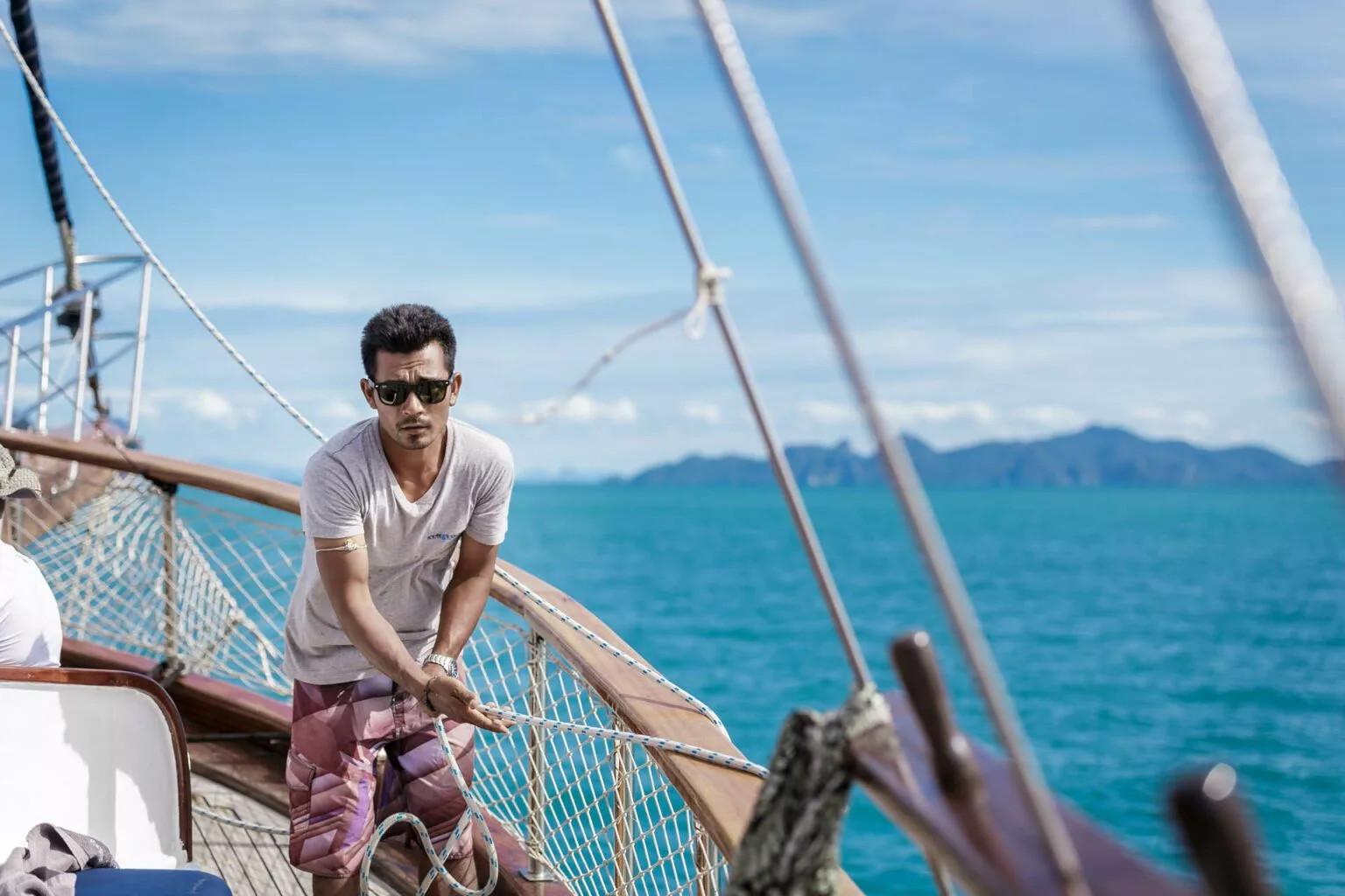 interpreter crew member rigging on the naga traditional yacht, samui, thailand